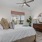 Bedroom with ceiling fan and large window